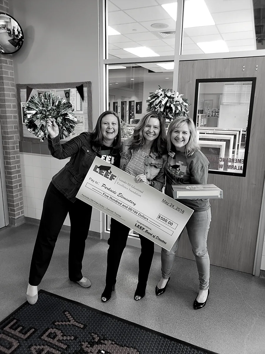 Kristen celebrating with educators holding a grant check