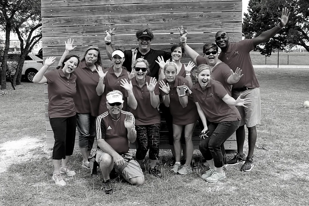 A cheering group of volunteers in matching shirts